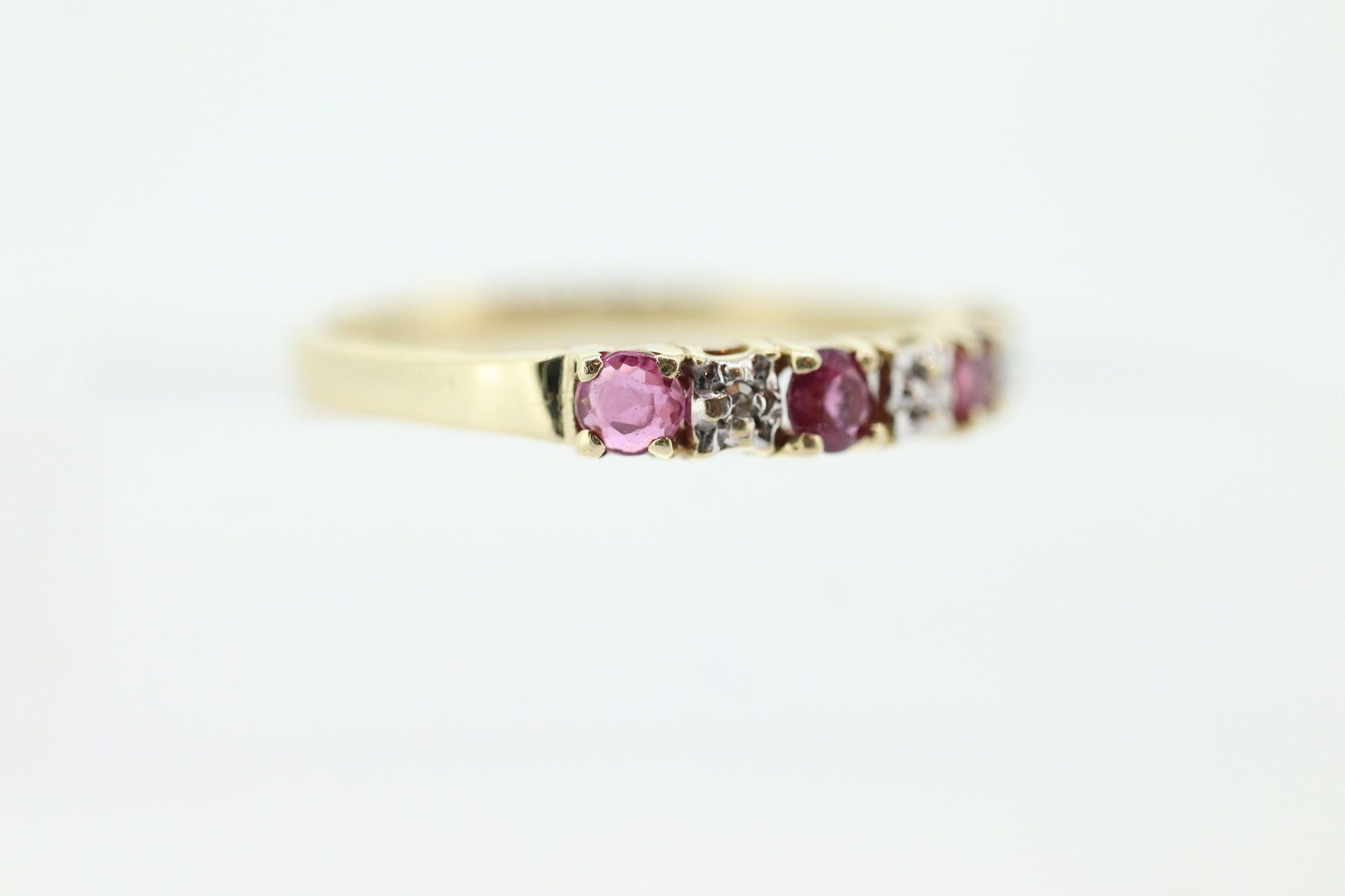 10k Anniversary Ruby Ring. A 10k gold ring with round Ruby and diamond accents eternity band. st(72)