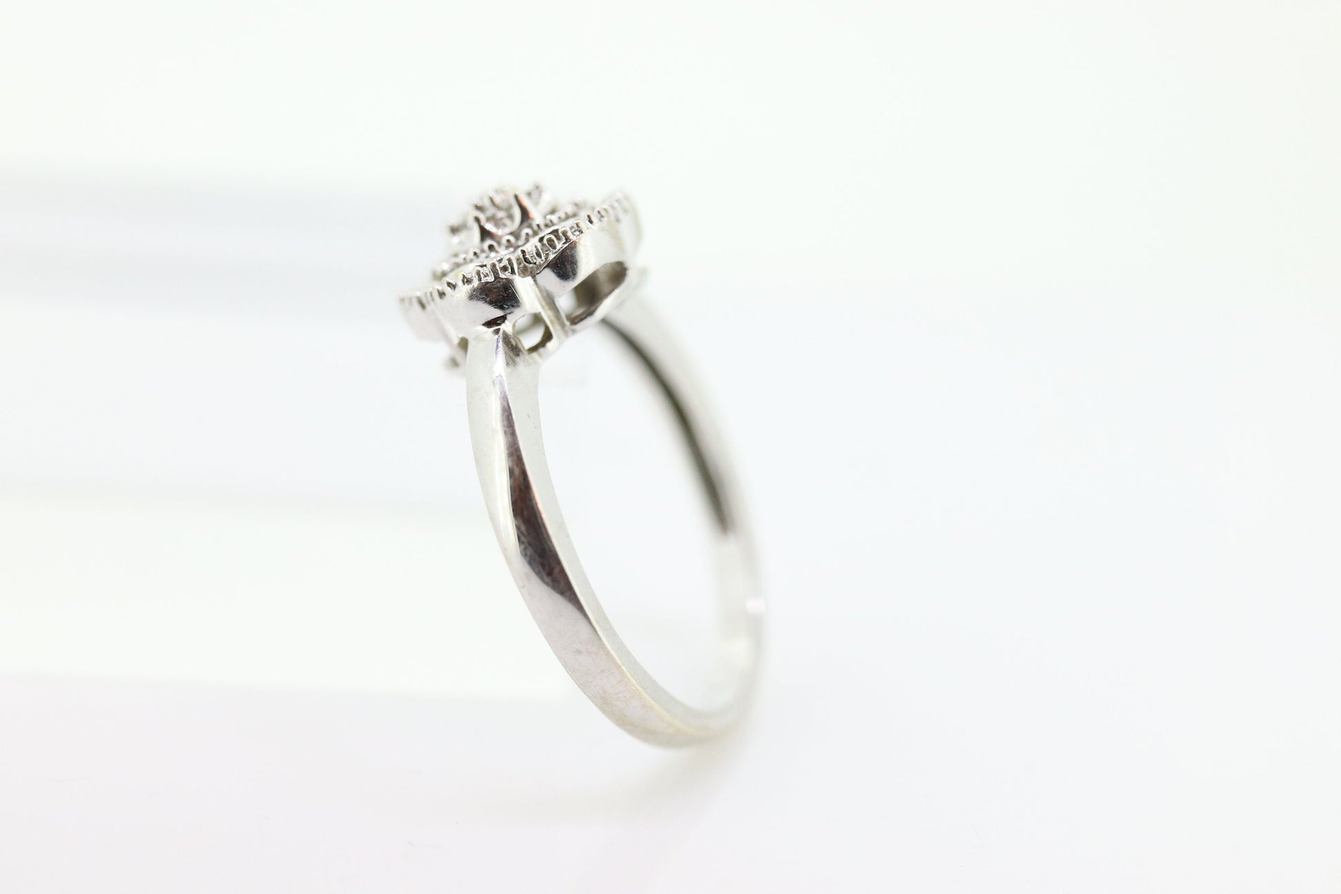 Diamond Daisy Cluster Elevated Ring. 10k White gold with round baguette diamond flower arrangement. st(52/90)