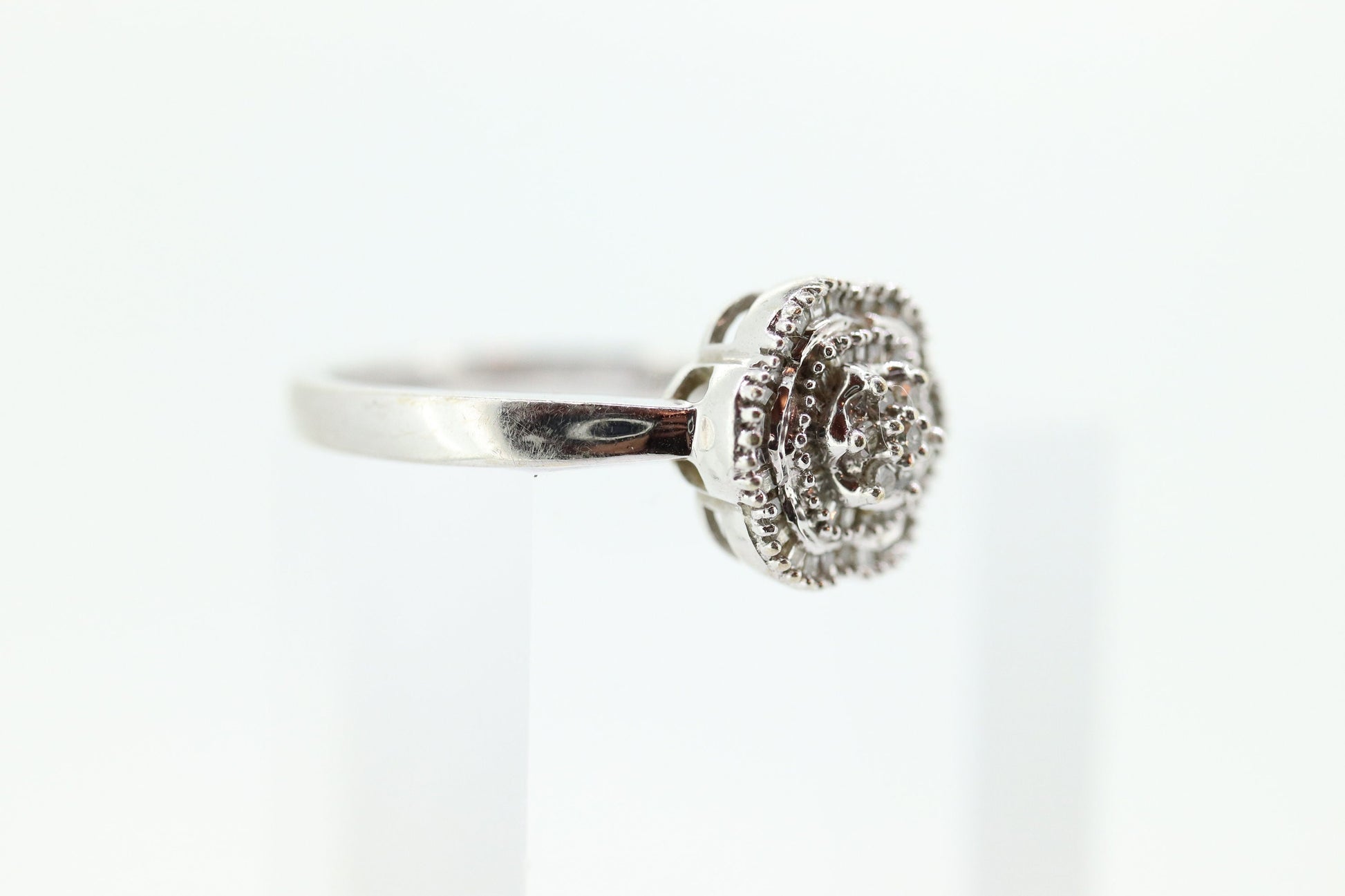 Diamond Daisy Cluster Elevated Ring. 10k White gold with round baguette diamond flower arrangement. st(52/90)