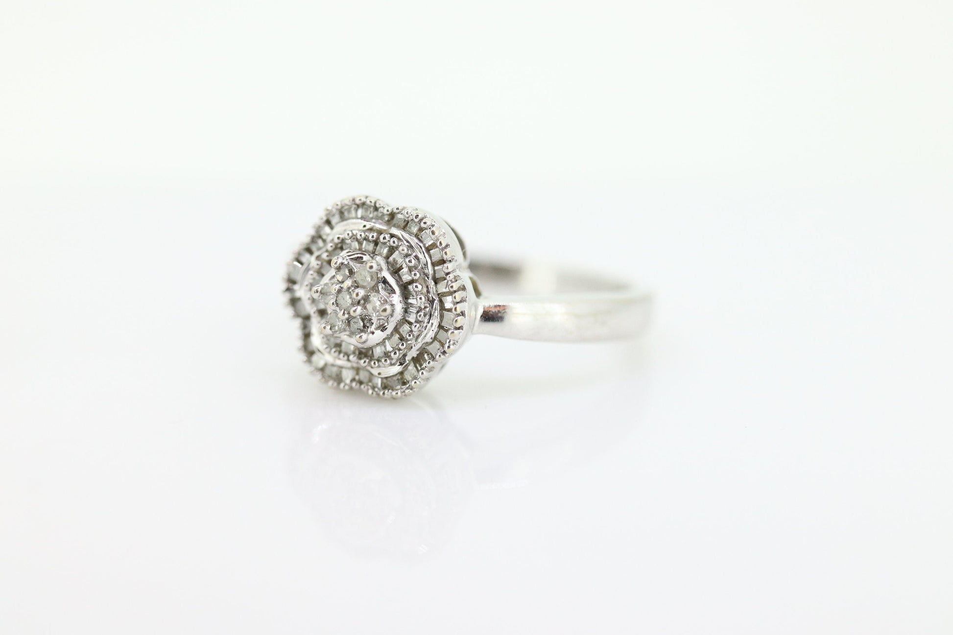 Diamond Daisy Cluster Elevated Ring. 10k White gold with round baguette diamond flower arrangement. st(52/90)