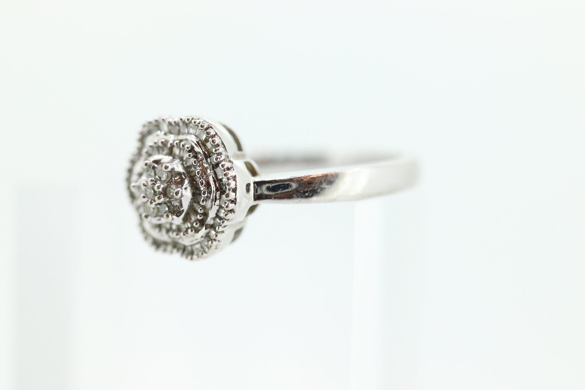 Diamond Daisy Cluster Elevated Ring. 10k White gold with round baguette diamond flower arrangement. st(52/90)