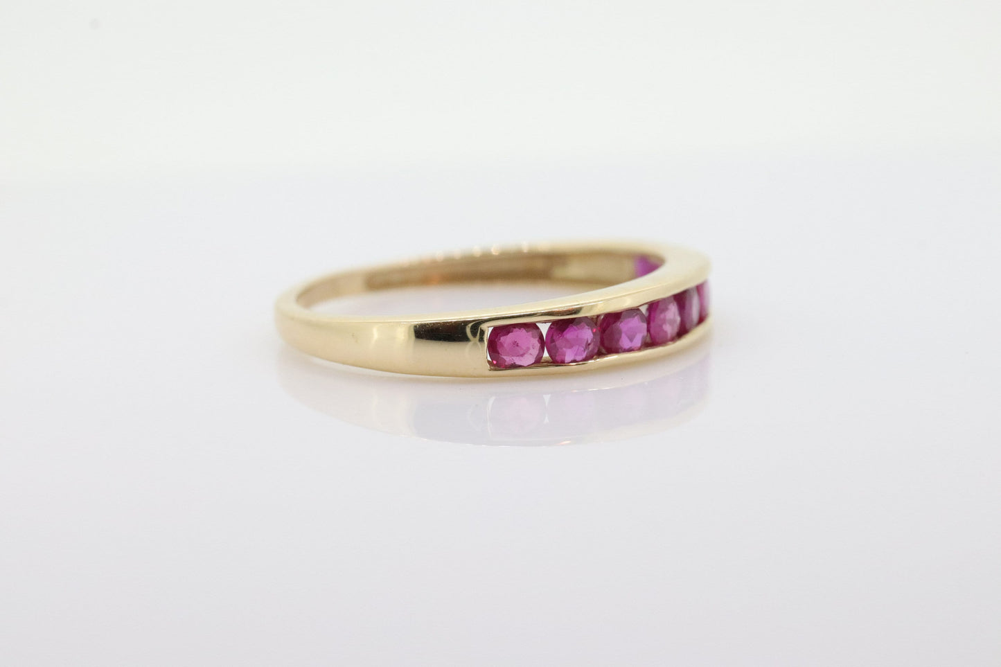 14k Eternity Half Ruby Ring. A 14k gold ring with round Ruby half eternity anniversary band. st(125)