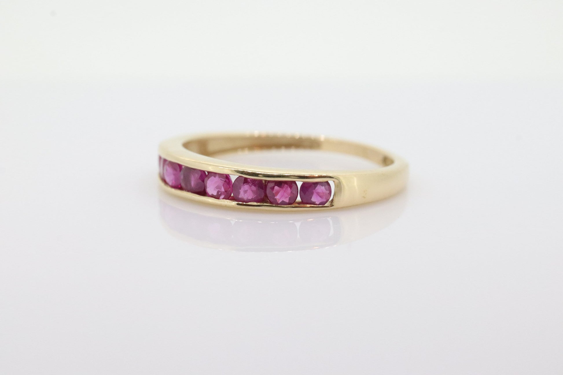 14k Eternity Half Ruby Ring. A 14k gold ring with round Ruby half eternity anniversary band. st(125)