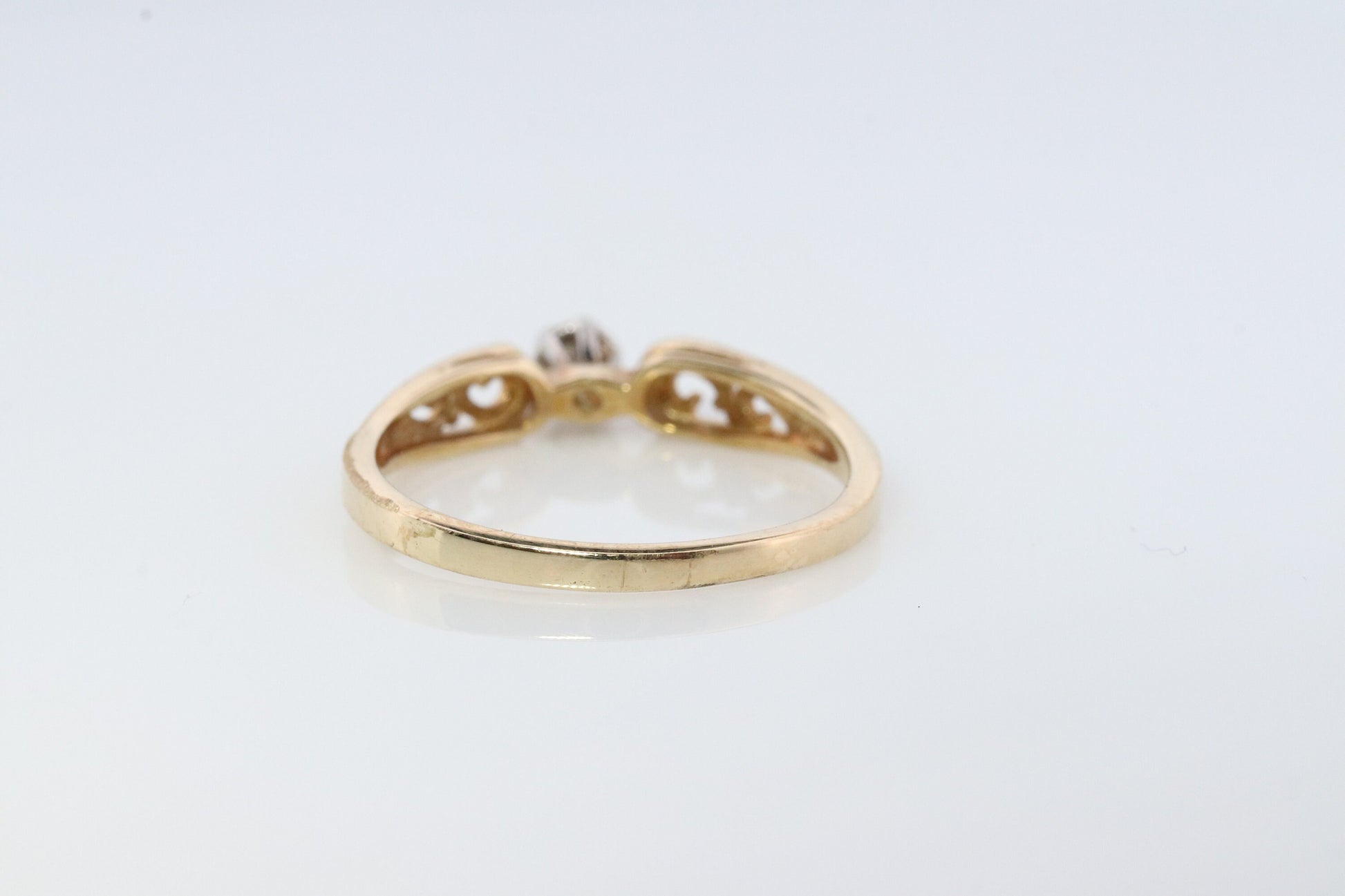 10k Diamond Solitaire. 10k Yellow gold engraved illusion set diamond ring. Filigree shank.
