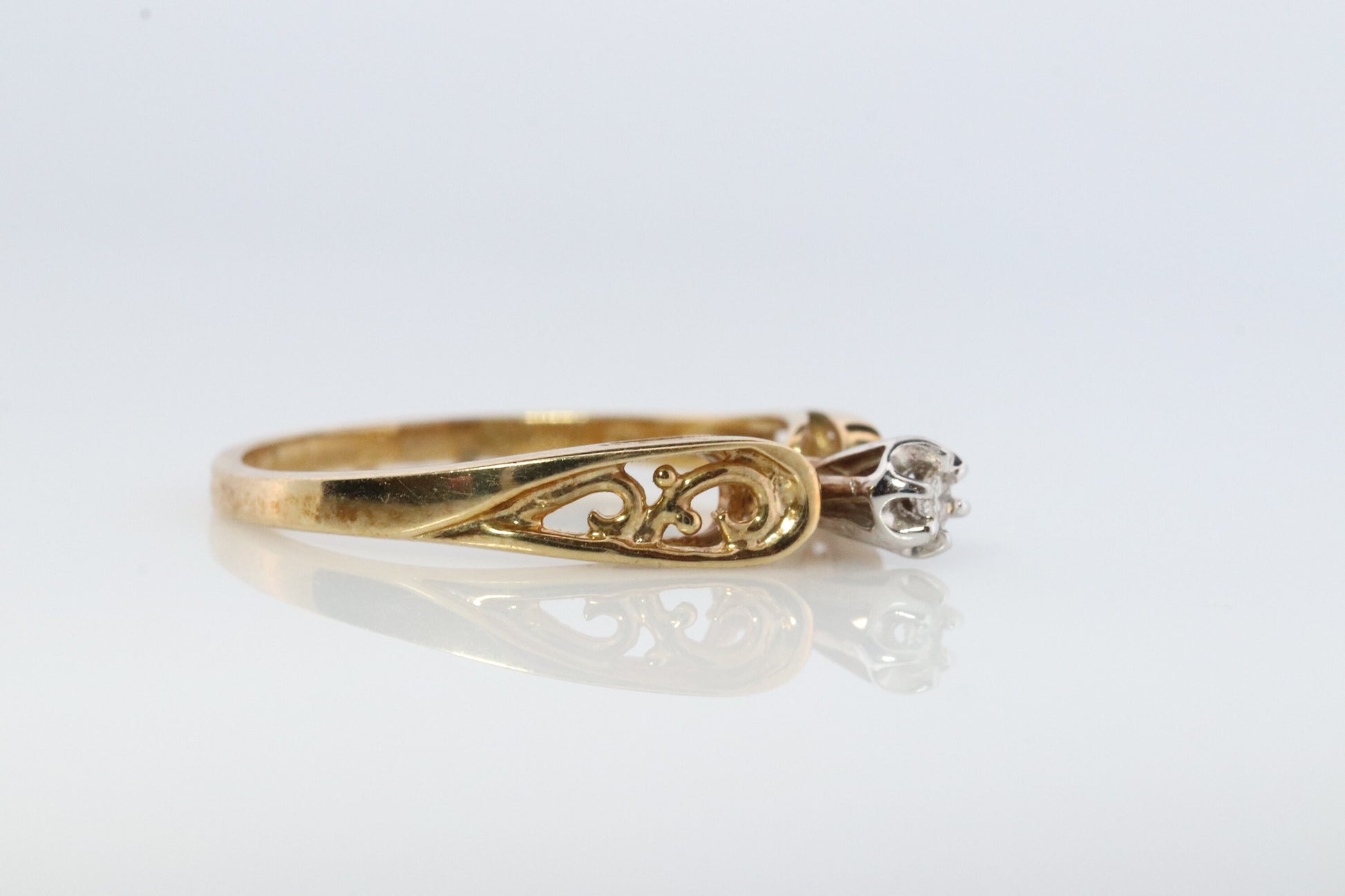 10k Diamond Solitaire. 10k Yellow gold engraved illusion set diamond ring. Filigree shank.