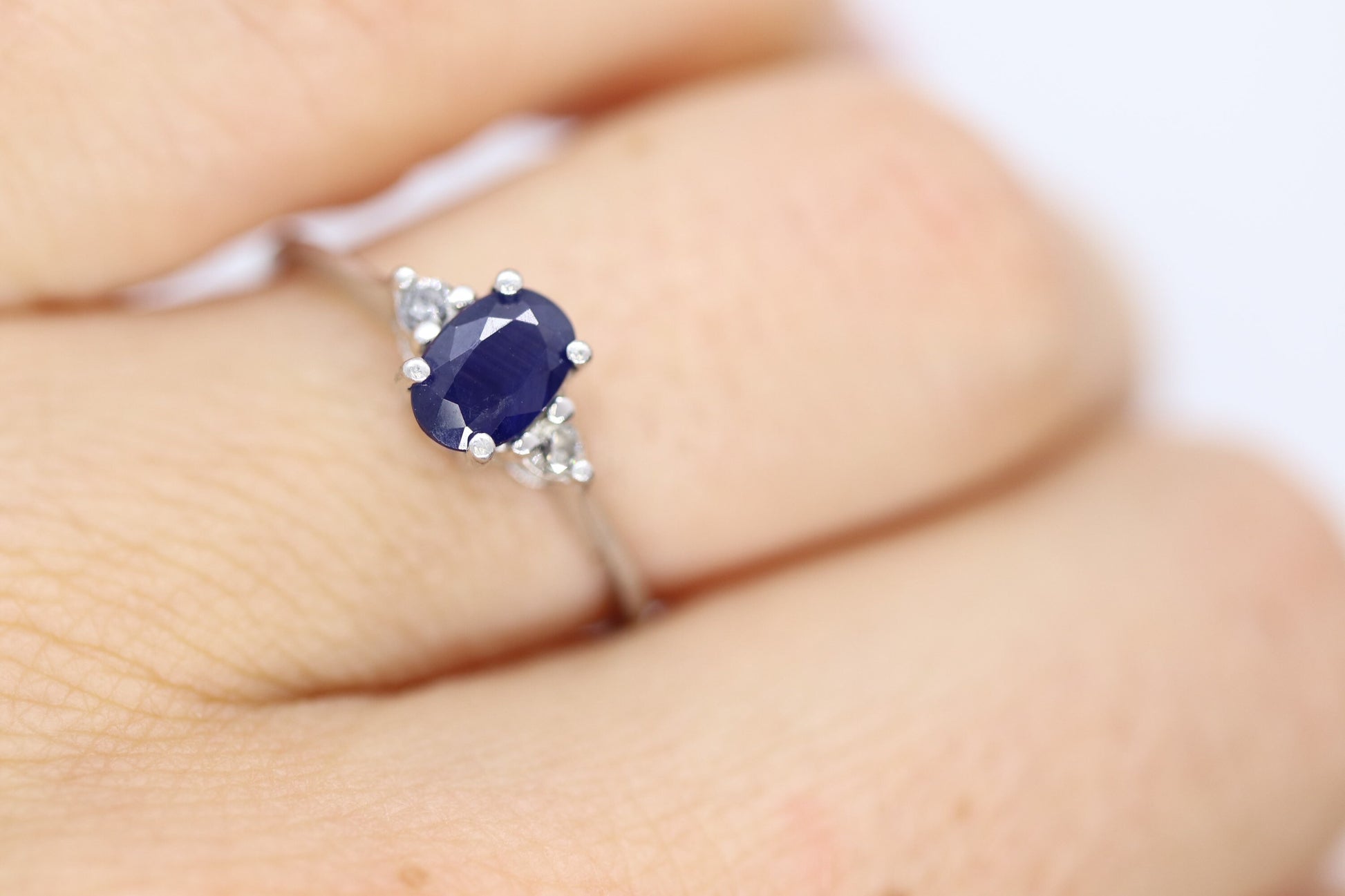 Platinum Sapphire and diamond ring. Oval blue Sapphire solitaire with Diamond accents trilogy ring.