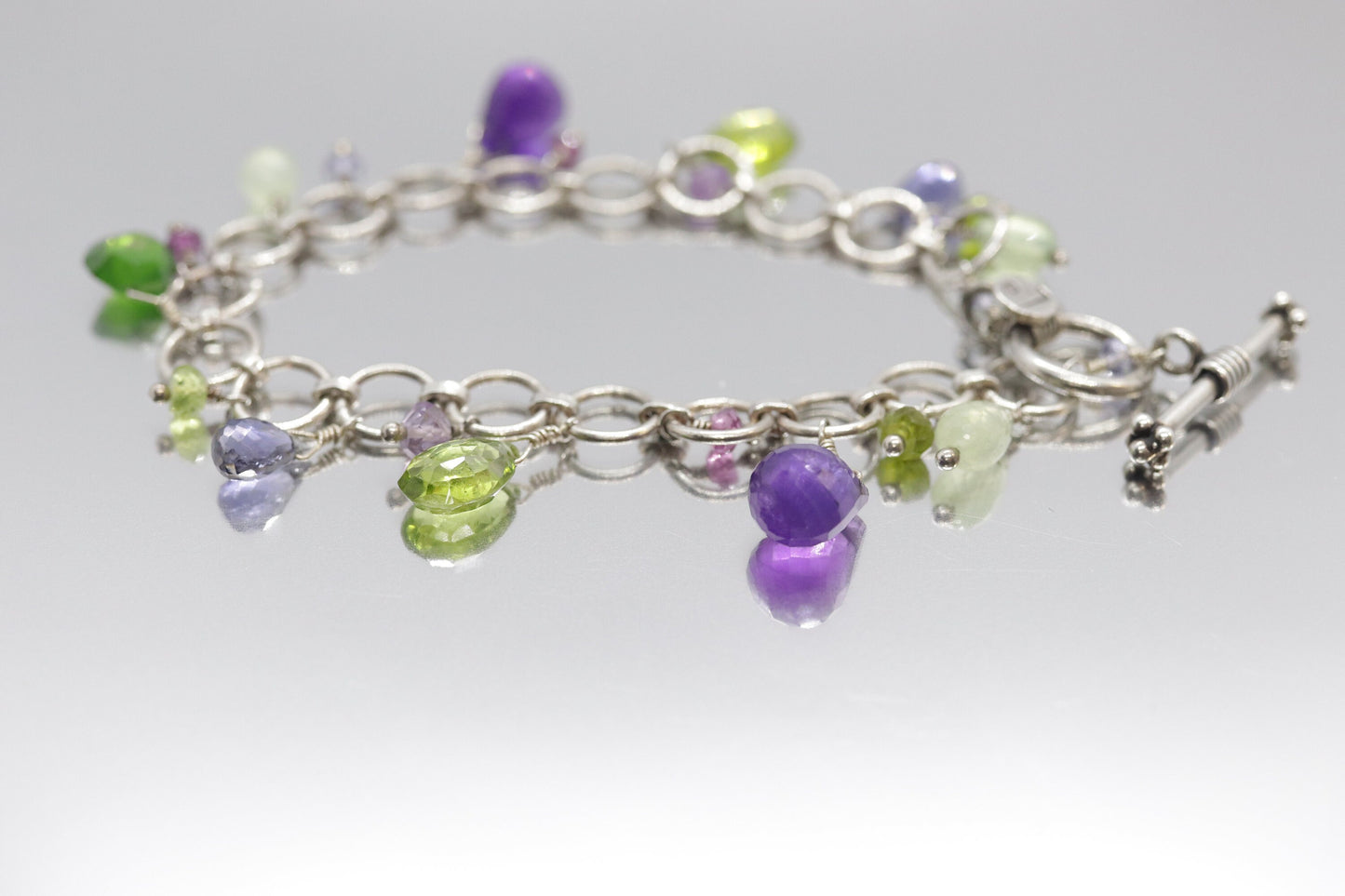 Laura Gibson Bracelet. Sterling Silver with Dangling Faceted Gems - Amethyst (464)