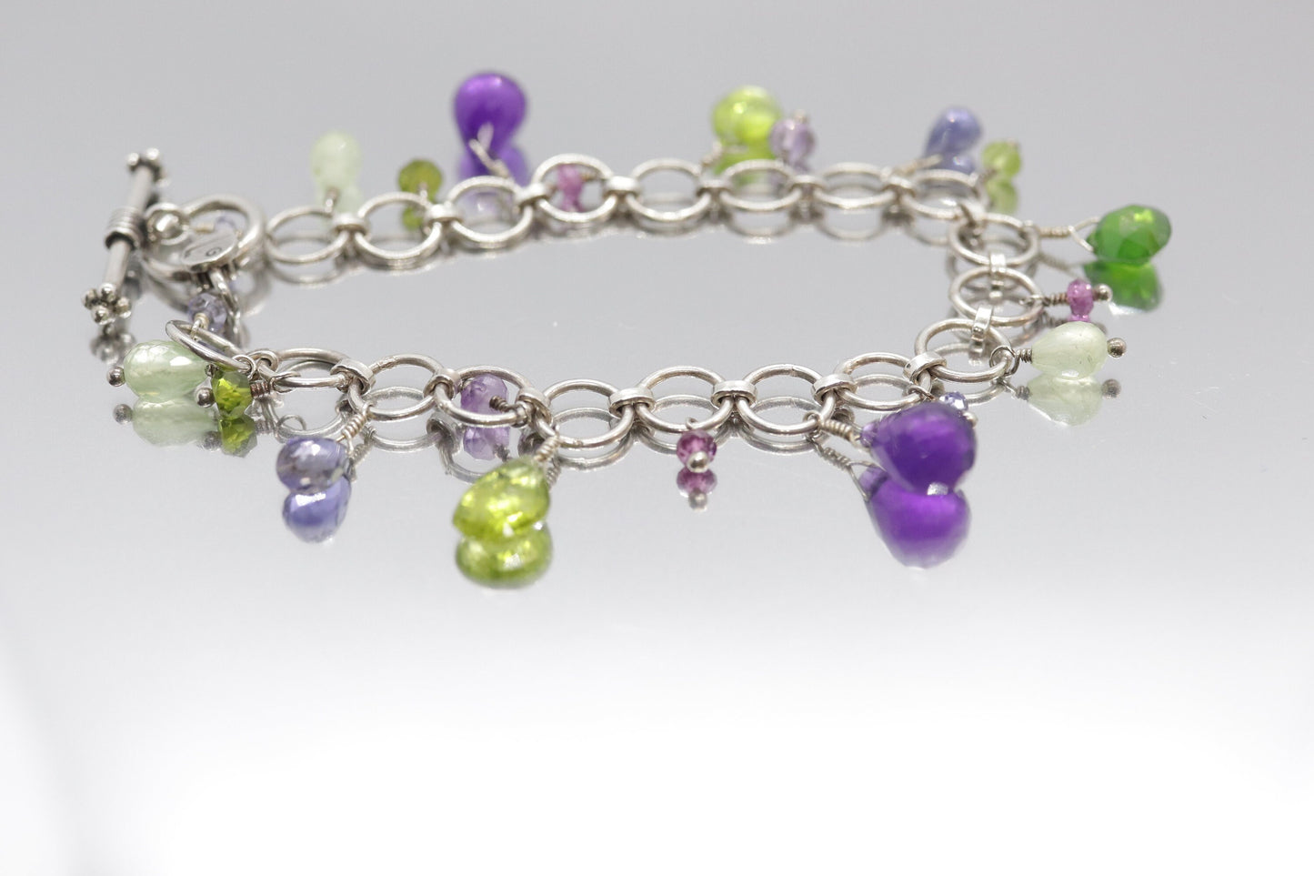 Laura Gibson Bracelet. Sterling Silver with Dangling Faceted Gems - Amethyst (464)