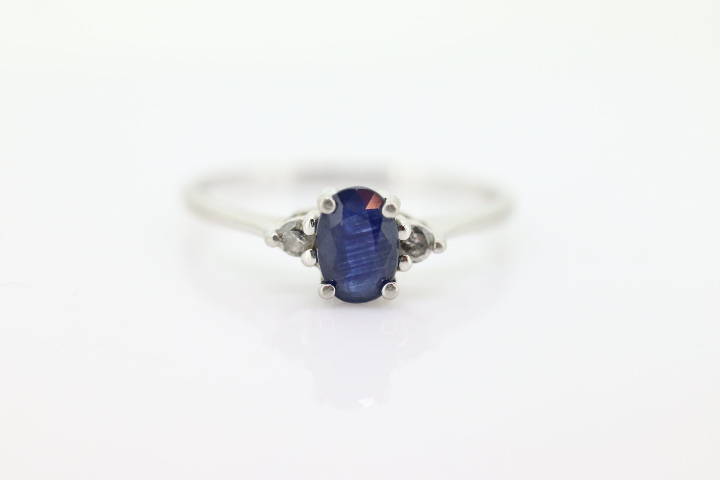 Platinum Sapphire and diamond ring. Oval blue Sapphire solitaire with Diamond accents trilogy ring.