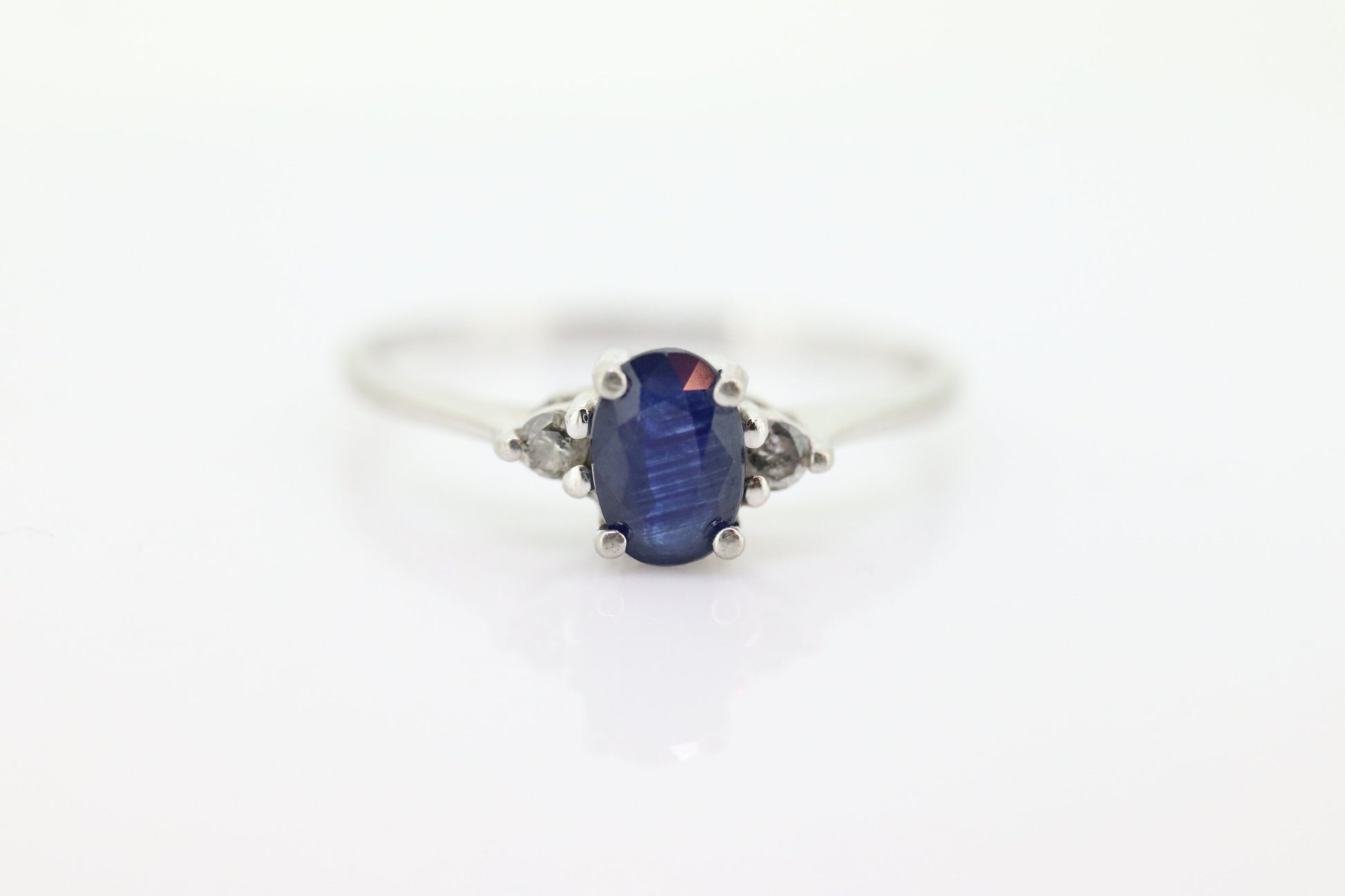 Platinum Sapphire and diamond ring. Oval blue Sapphire solitaire with Diamond accents trilogy ring.