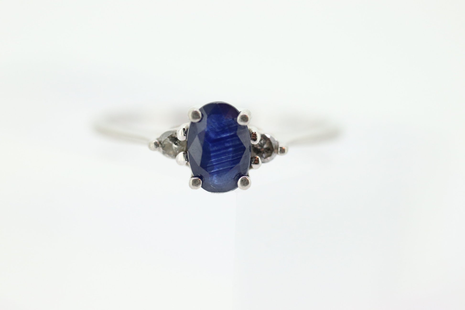 Platinum Sapphire and diamond ring. Oval blue Sapphire solitaire with Diamond accents trilogy ring.