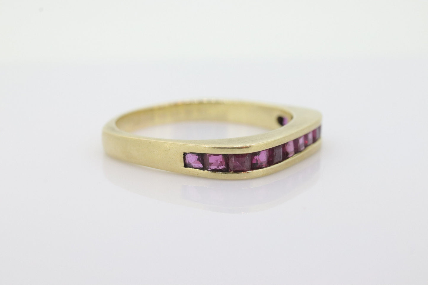 14k Eternity Half Ruby Ring. Euro Shank flat bottom. A 14k gold ring with Princess cut Ruby channel half calibre anniversary band. st(95)