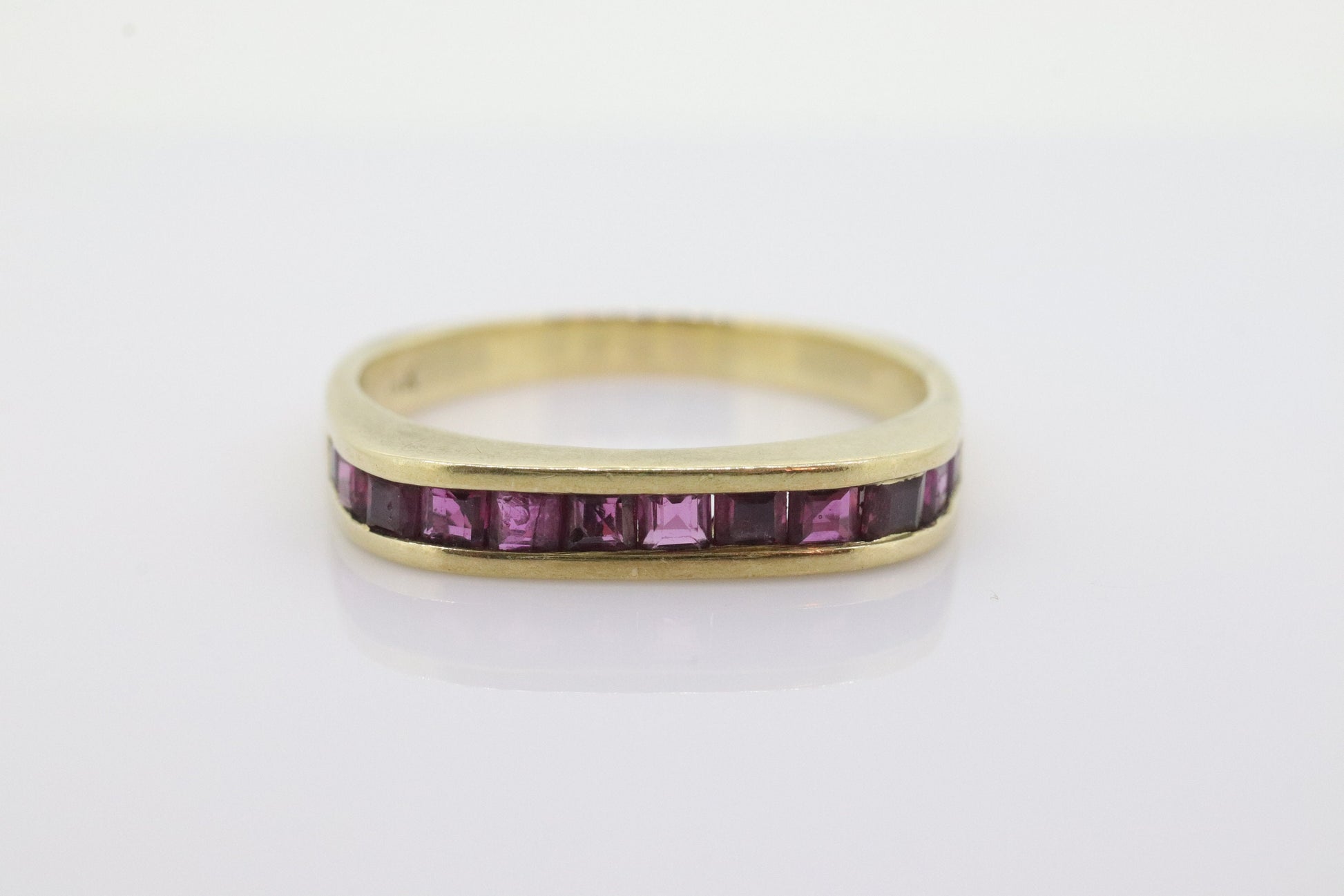 14k Eternity Half Ruby Ring. Euro Shank flat bottom. A 14k gold ring with Princess cut Ruby channel half calibre anniversary band. st(95)