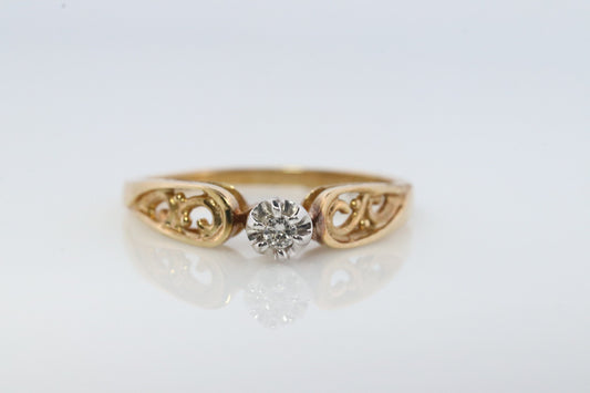 10k Diamond Solitaire. 10k Yellow gold engraved illusion set diamond ring. Filigree shank.